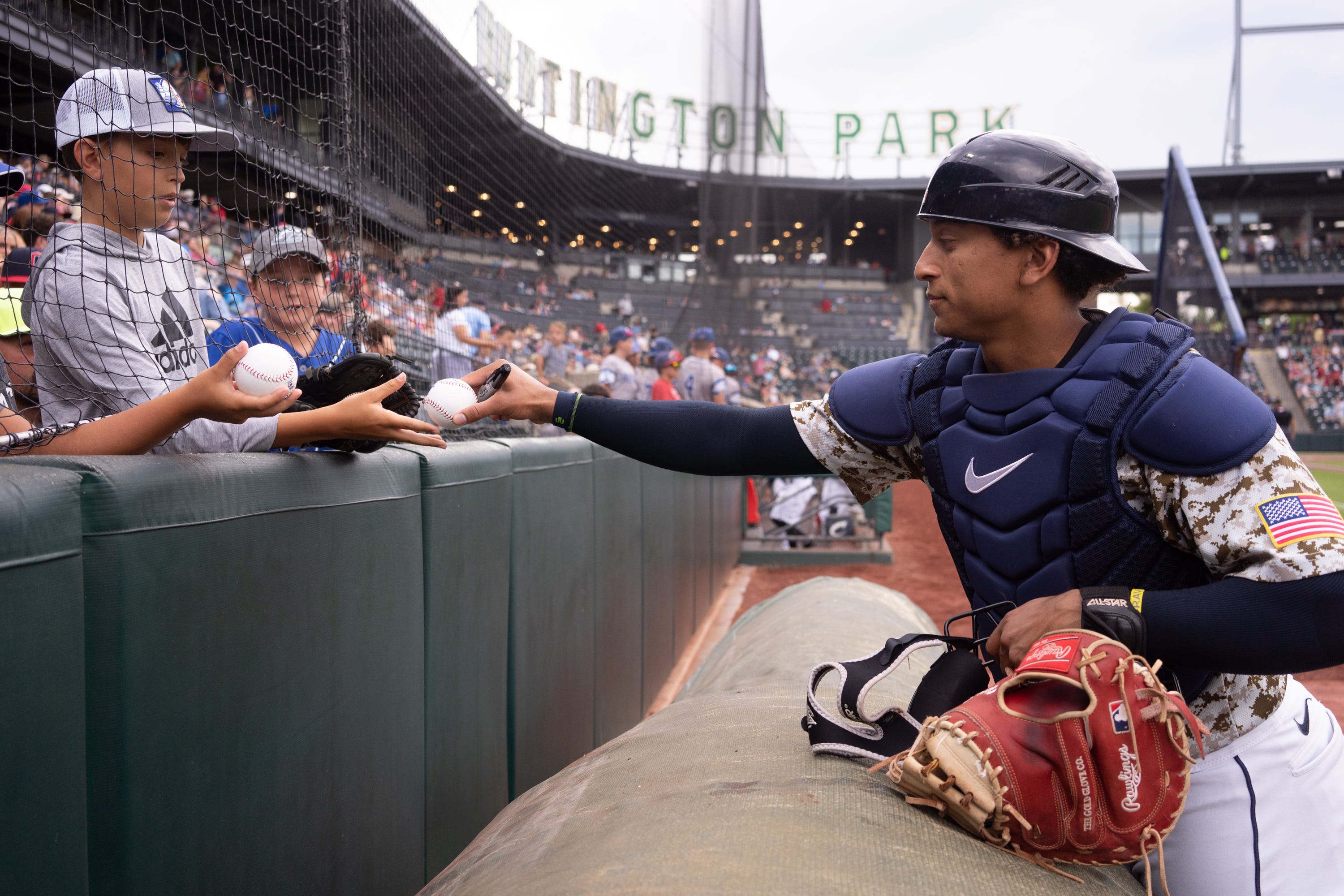 Columbus Clippers catcher Bo Naylor (since promoted to the Cleveland Guardians) signs baseballs for fans before a game at Huntington Park in July 2022.